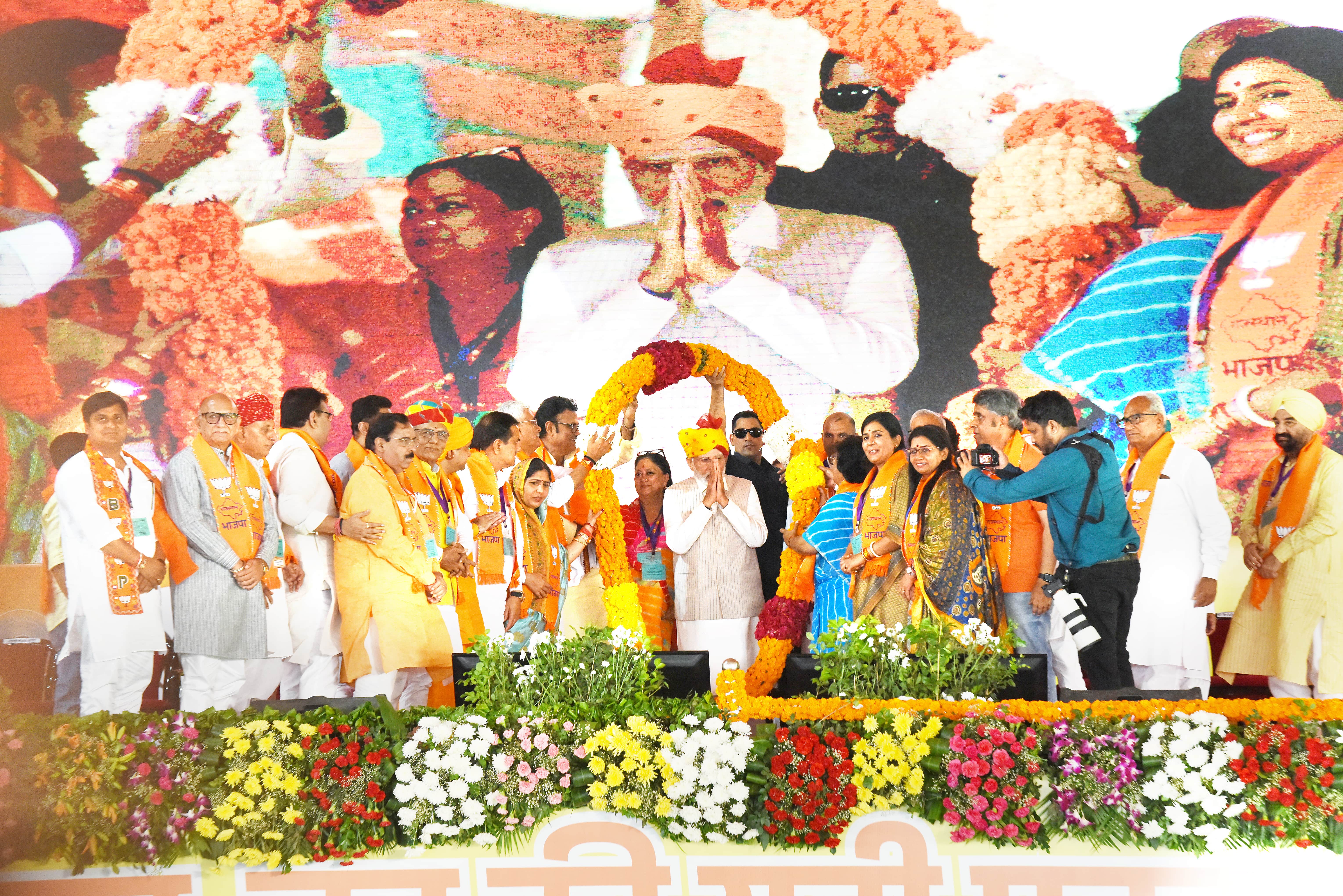 PM Narendra Modi greeting the gathering as senior party leaders garland him at Dadiya, Jaipur