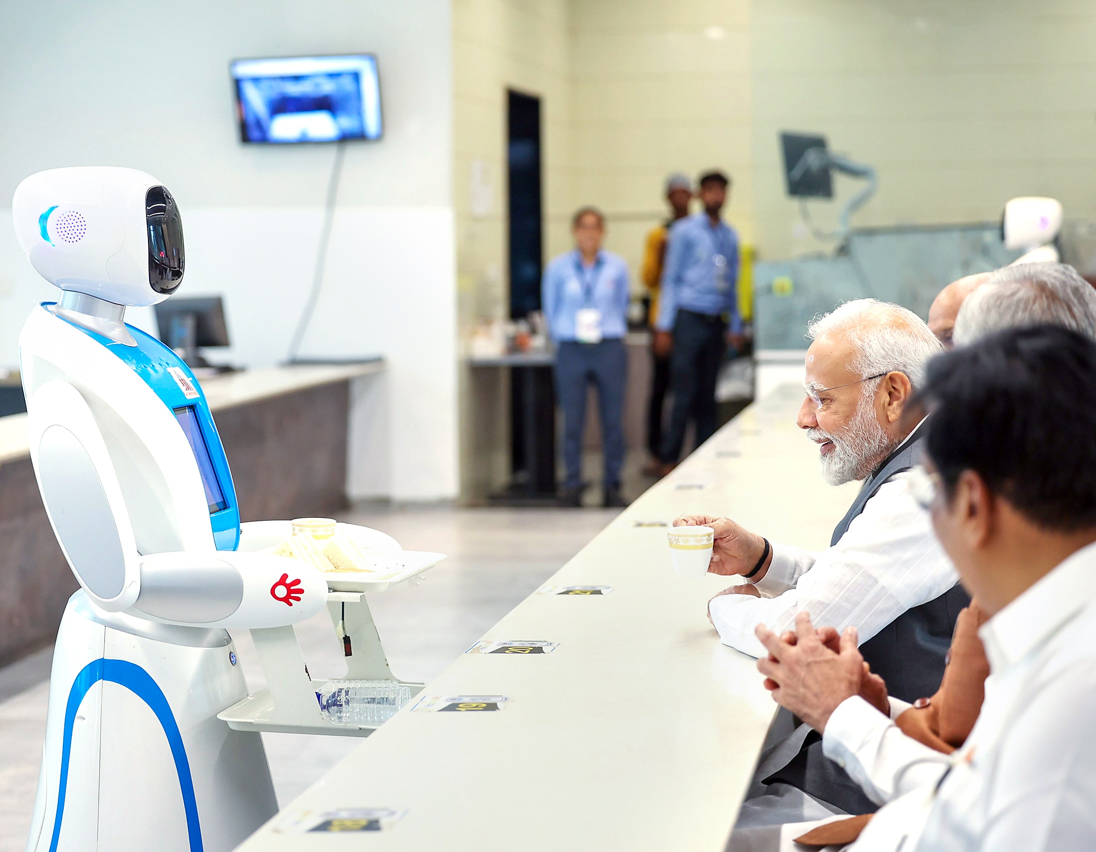 PM Narendra Modi enjoys tea served by a Robot in presence of Acharya Devvrat, Bhupendra Patel and CR Paatil.