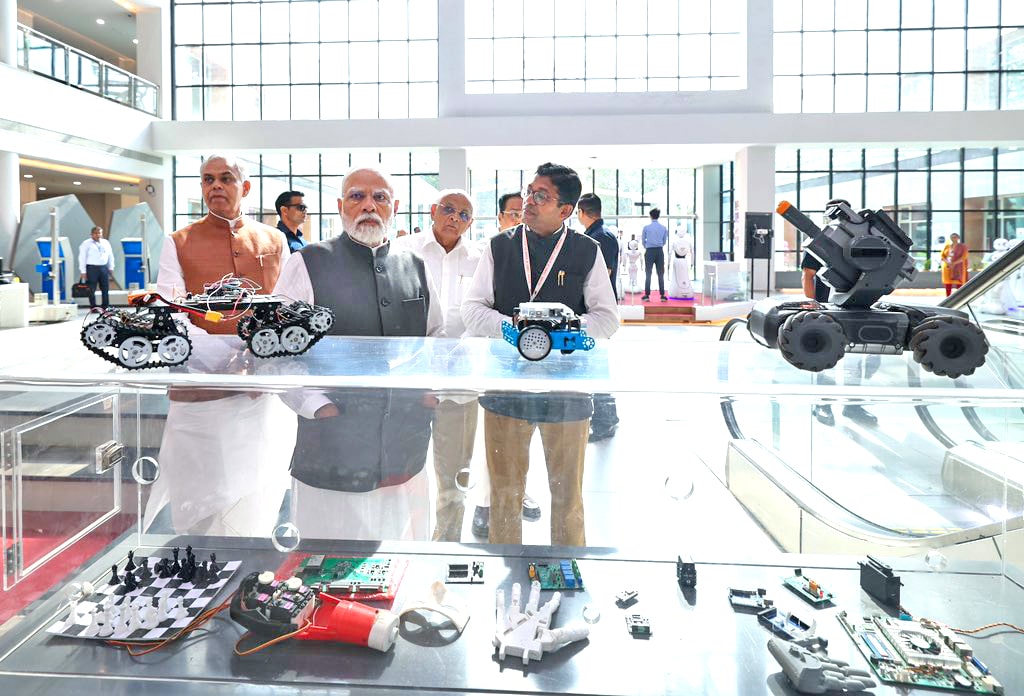PM Modi scans the gadgets during his visit to Robotics Gallery. Acharya Devvrat, Bhupendra Patel and CR Paatil are also seen.