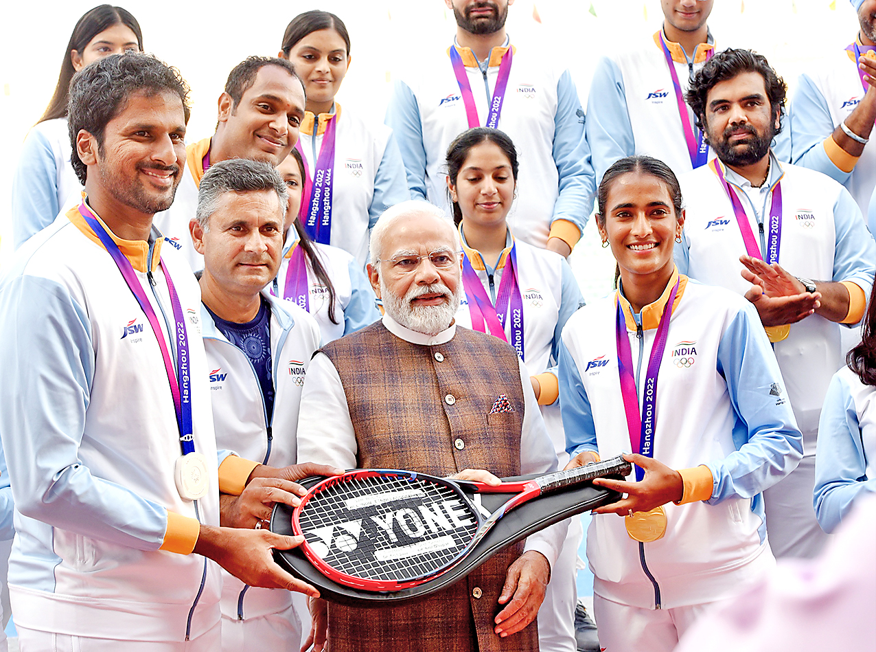 The Prime Minister being presented a racquet by players and coach.