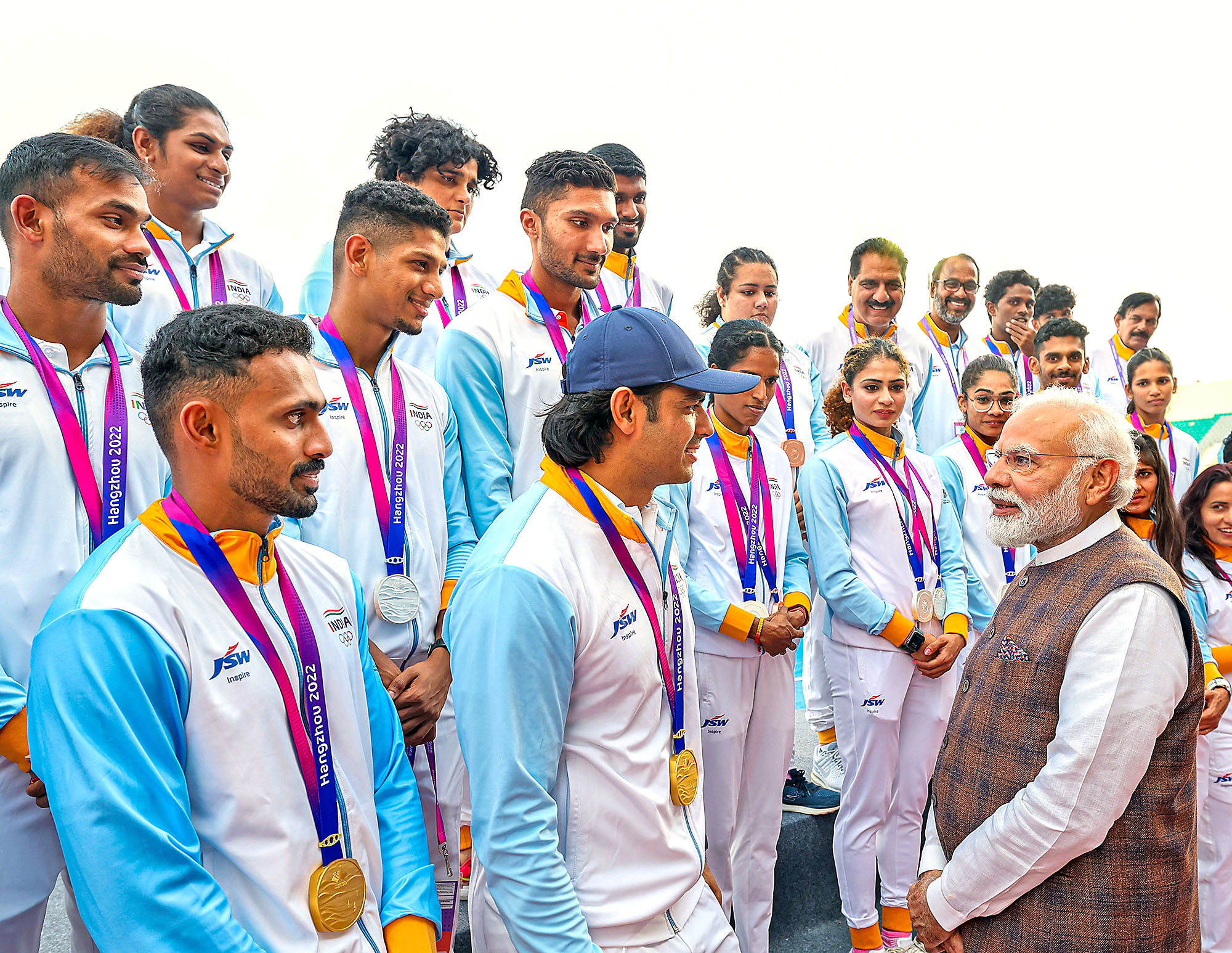 PM Modi interacts with Neeraj Chopra as other players look on.