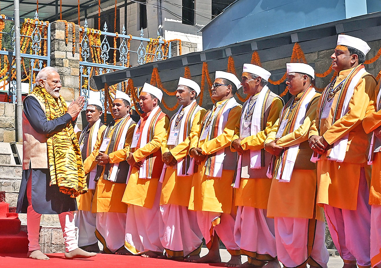 Prime Minister Narendra Modi greets priests during offering prayers at Jageshwar Dham.