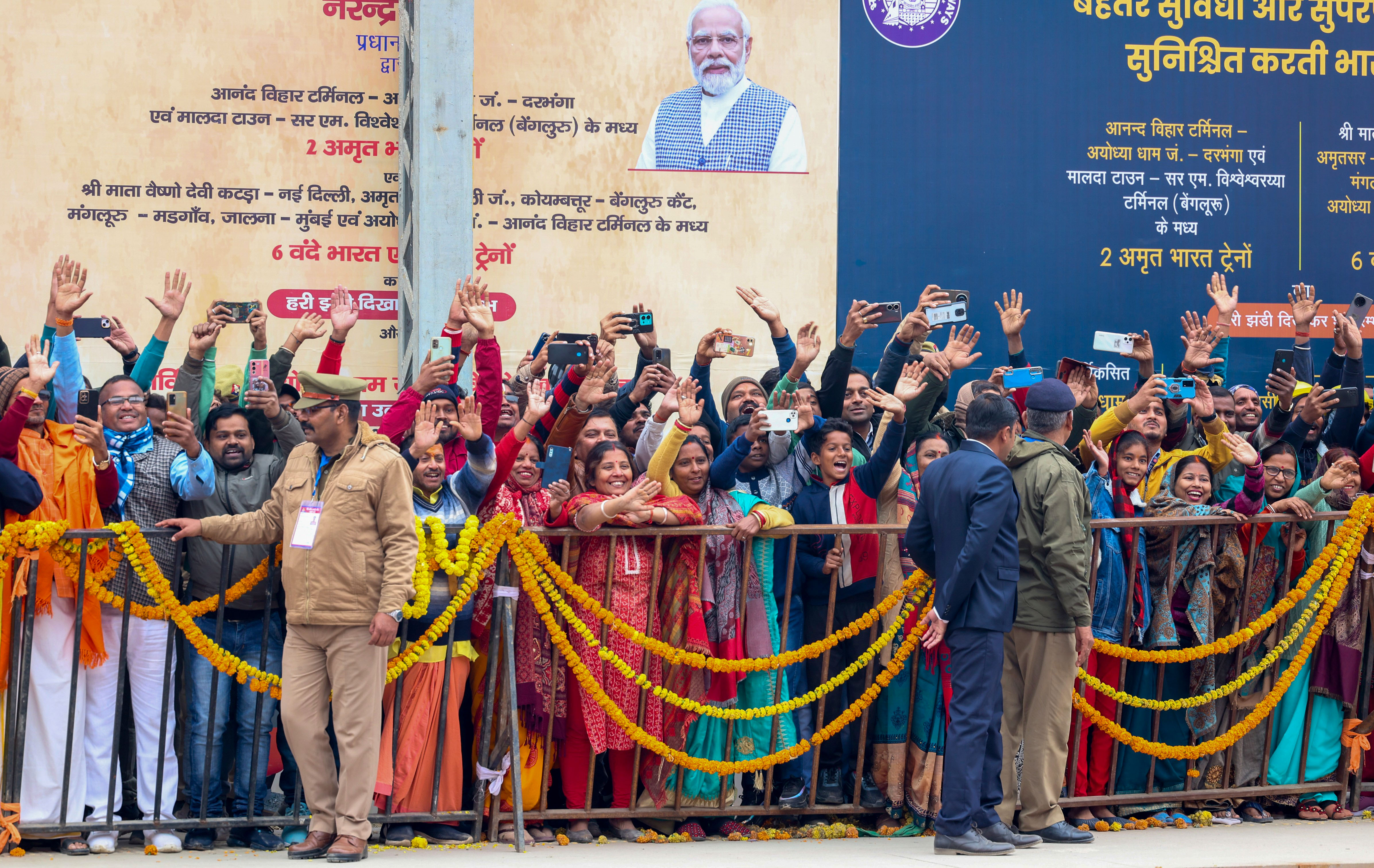 People wave to Prime Minister Narendra Modi (unseen) at the flagging off of two new Amrit Bharat trains and six new Vande Bharat Trains, in Ayodhya on Saturday.