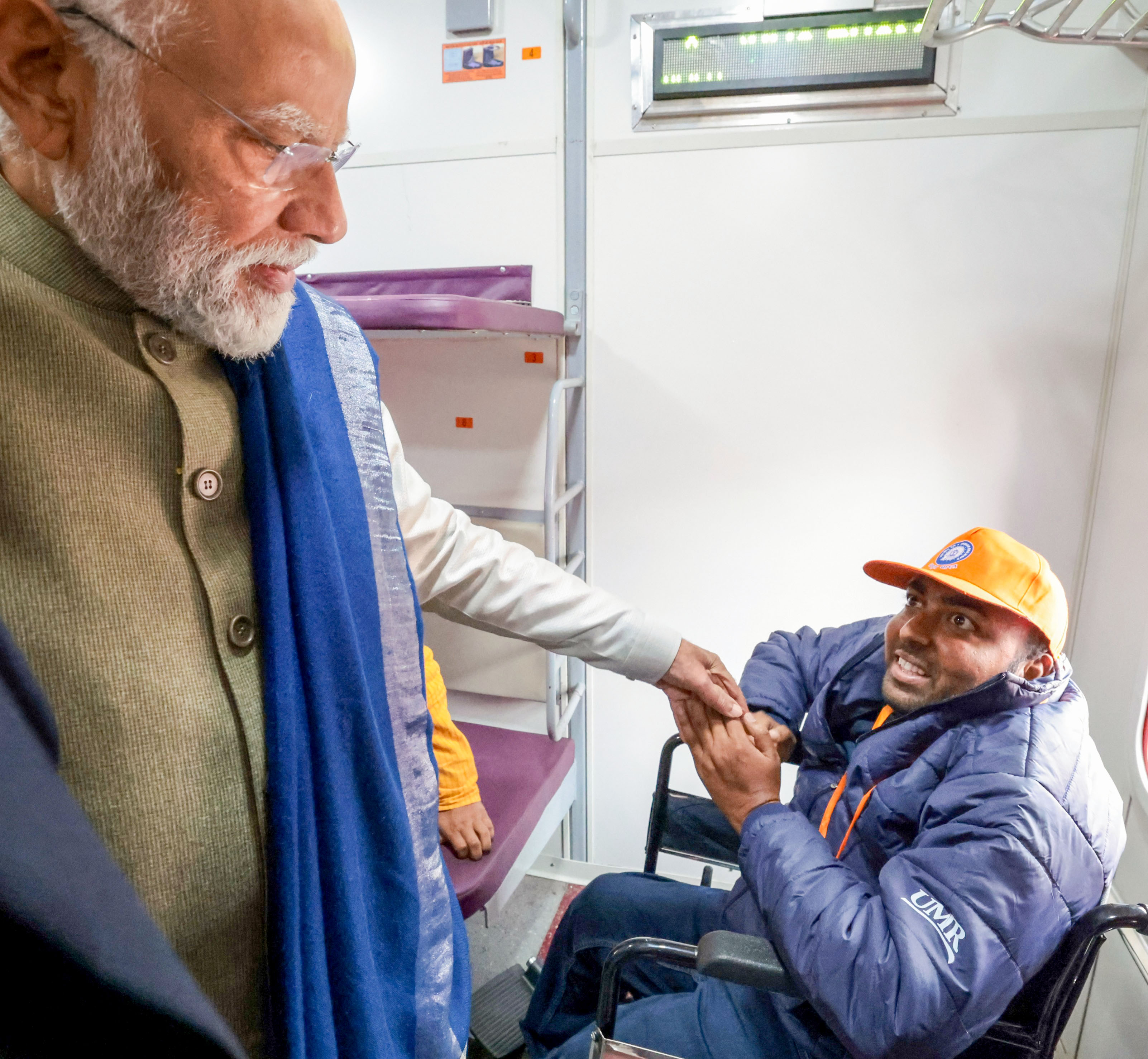 Prime Minister Narendra Modi interacts with a specially-abled passenger onboard the Amrit Bharat train after inaugurating it, in Ayodhya on Saturday.